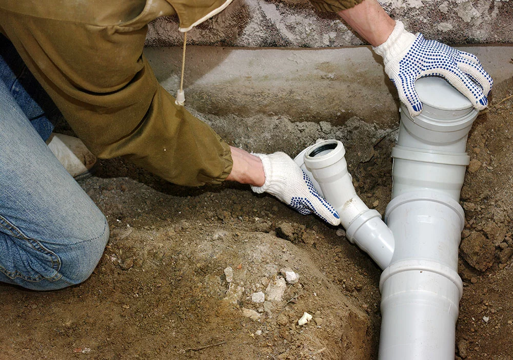 a person fixing a drain pipe