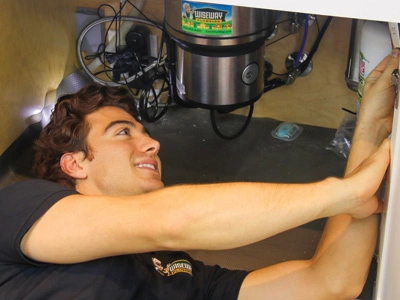 Technician in the process of repairing the garbage disposal