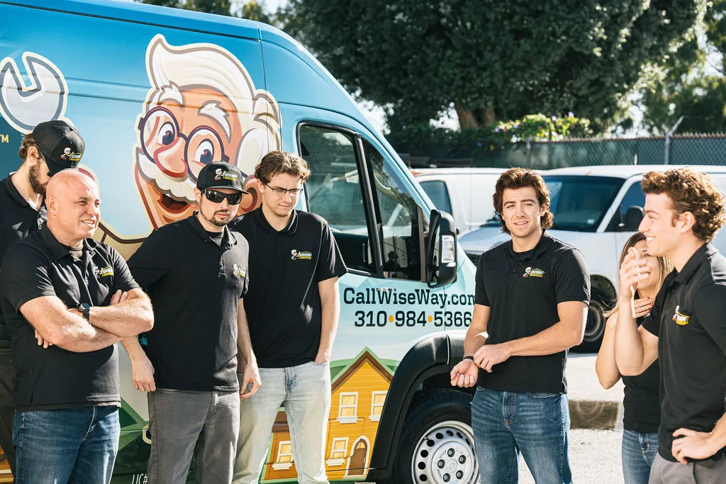 Wiseway plumbers chatting by branded Wiseway service truck