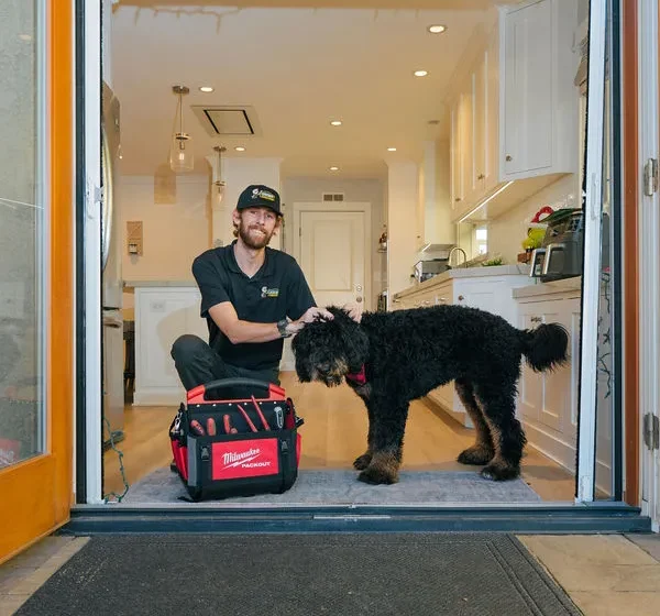 Tehcnician with dog at customer home