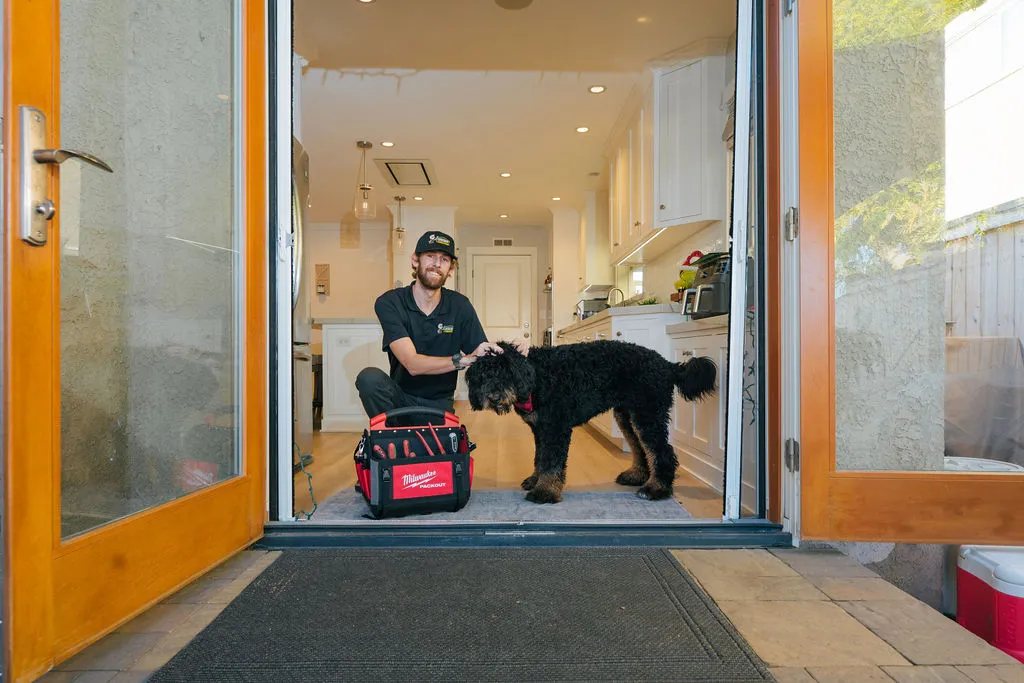 Tehcnician with dog at customer home